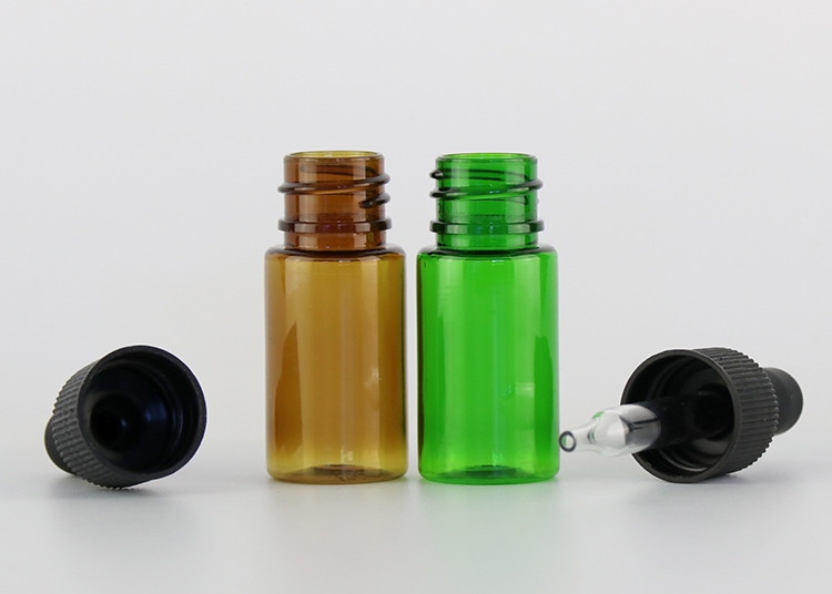 As garrafas de óleo essencial vazias de vidro pequenas alisam a superfície com conta-gotas plástico